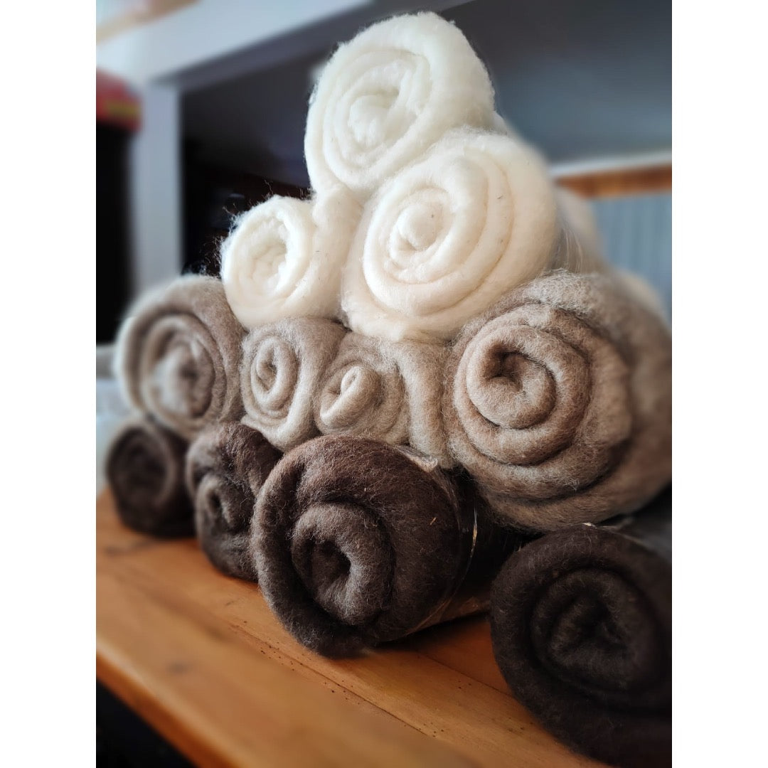 A pyramid of 11 rolled batts on a table