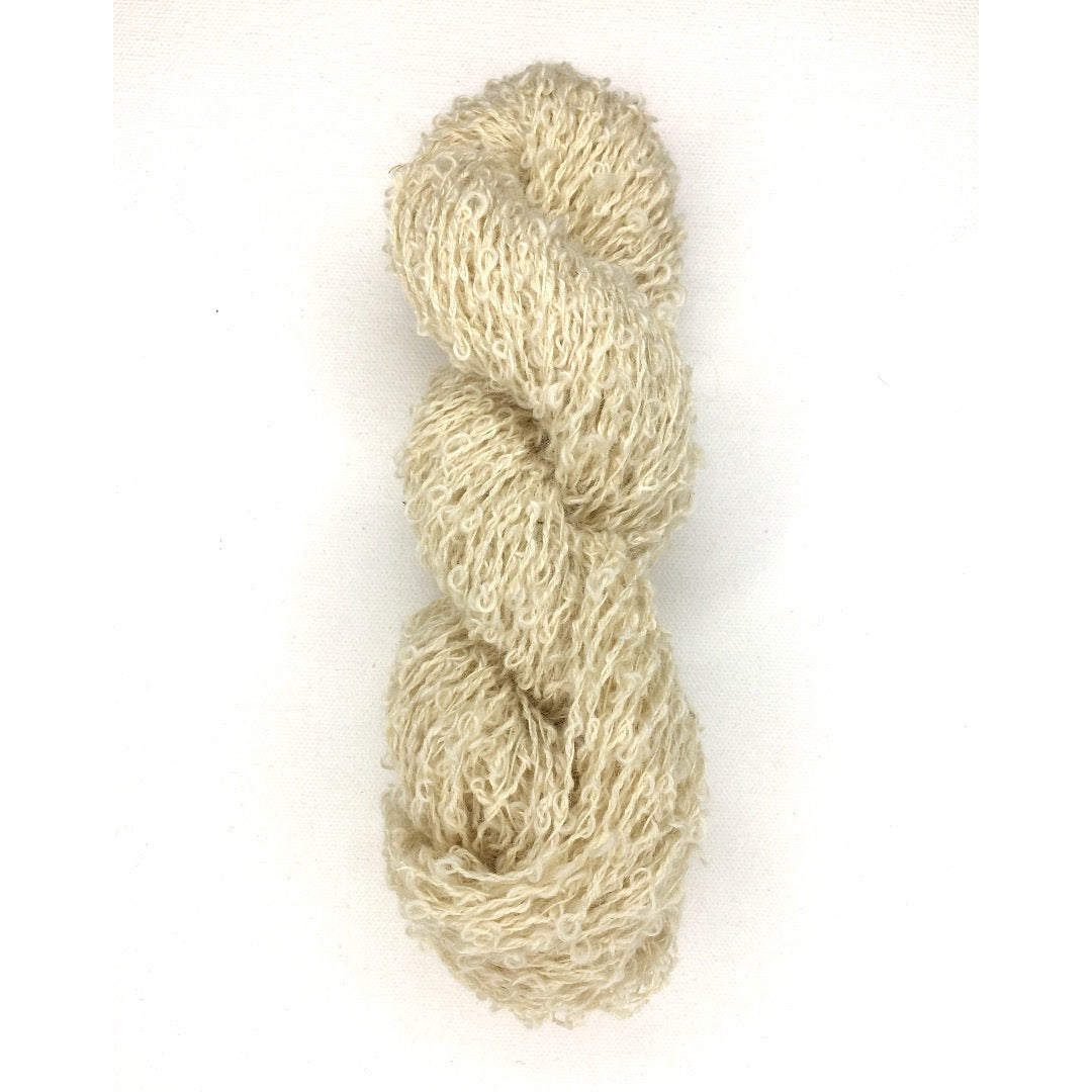 A single hank of soft beige DK Boucle yarn