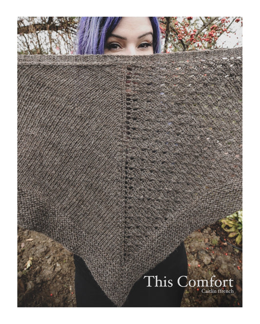 Knitwear designer holding up This Comfort Shawl across her face 
