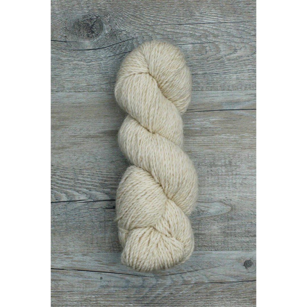 One hank of creamy white Ramo Worsted weight yarn with just a hint of red