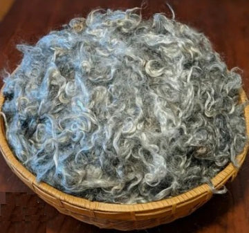 Woven basket filled with washed grey mohair locks