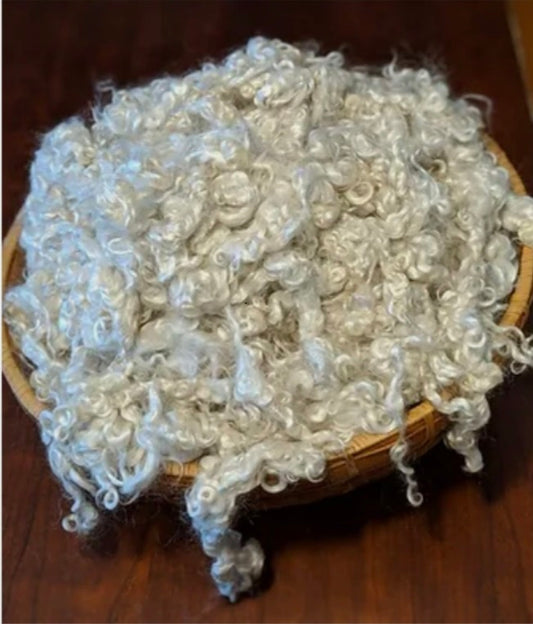 Woven basket filled with washed white mohair locks